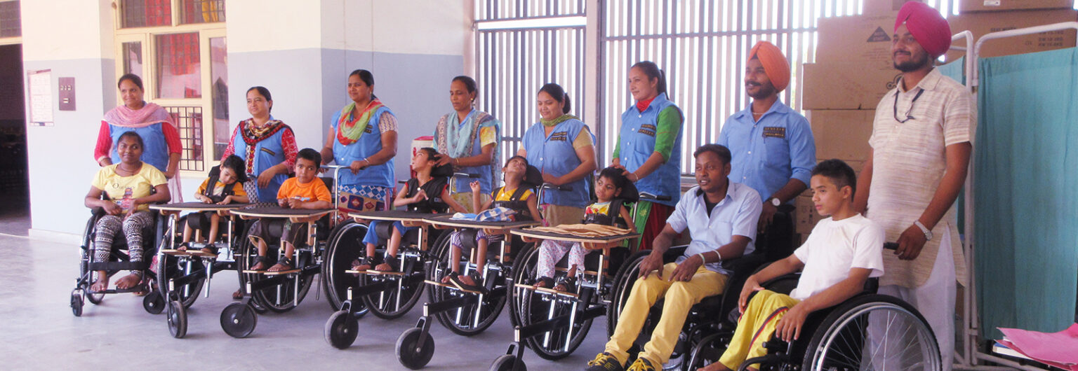 Differently-abled children in wheelchairs with caregivers at a support center
